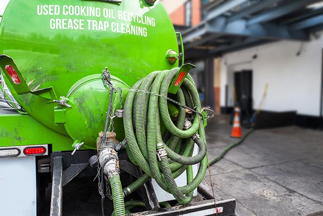 a technician pumping a grease trap in a commercial building in Browns Valley